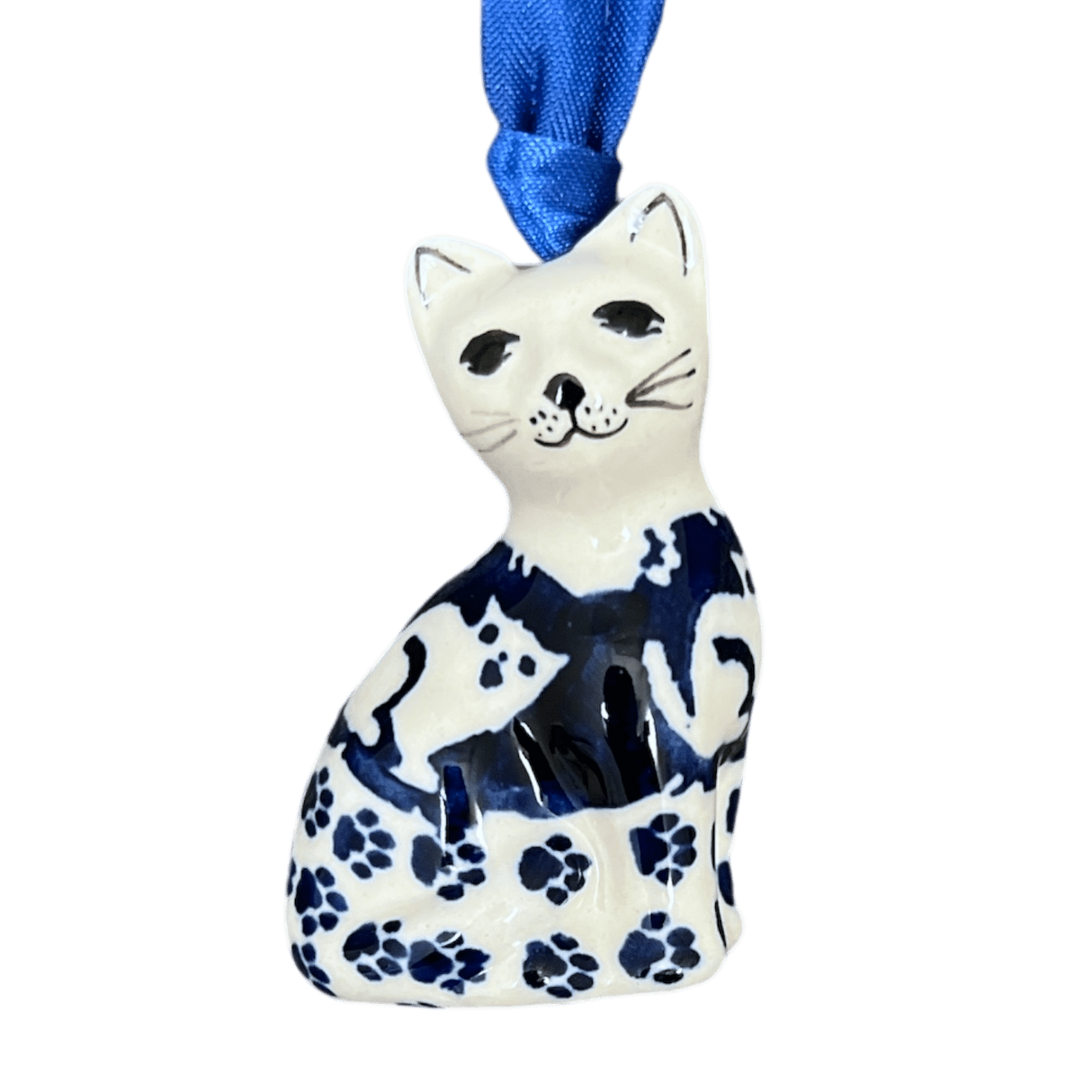 A blue and white ceramic cat ornament with a floral pattern and a blue ribbon attached for hanging.