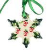 Decorative snowflake ornament with red berries and green leaves on a white background