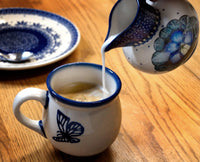 A picture of a Polish Pottery Big Belly Creamer (Floral Peacock) | D008T-54KK as shown at PolishPotteryOutlet.com/products/big-belly-creamer-floral-peacock